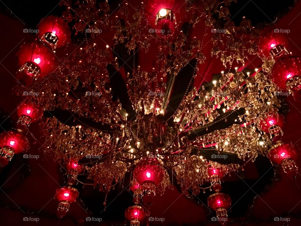 Ornate red lanterns arranged into an enormous chandelier spanning the width of a ballroom ceiling. House on the Rock, WI