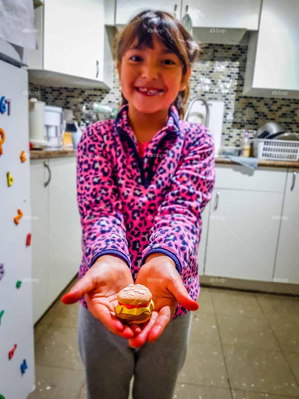 Happy crafty creator: cute girl with hamburger made of moulding clay