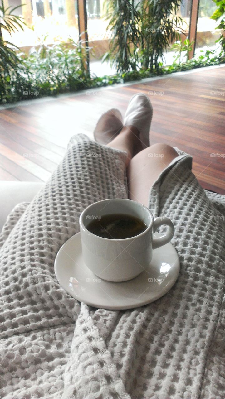 Woman drinking tea and relaxing at spa resort.