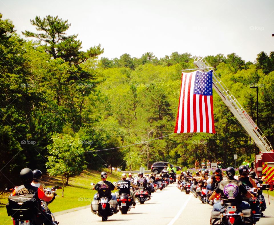Riding Under Enormous 🇺🇸Flag. An enormous American Flag🇺🇸was set up for our ride. Brought us to tears, speeches were given-we knew why we were there