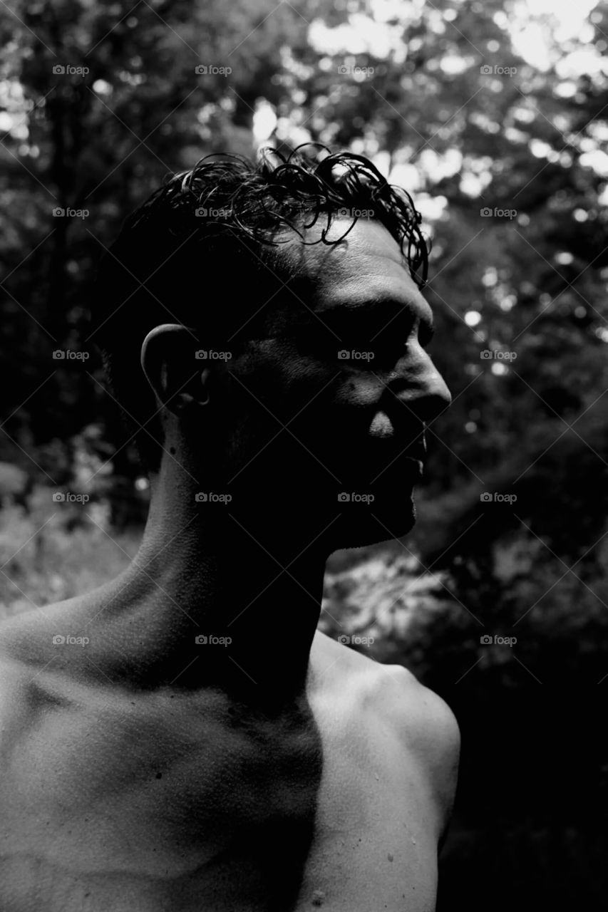 Black and white profile view of man in the woods