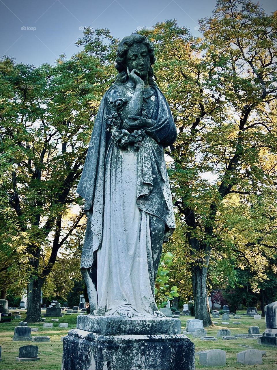 An eerily beautiful gravestone on a chilly autumn evening 