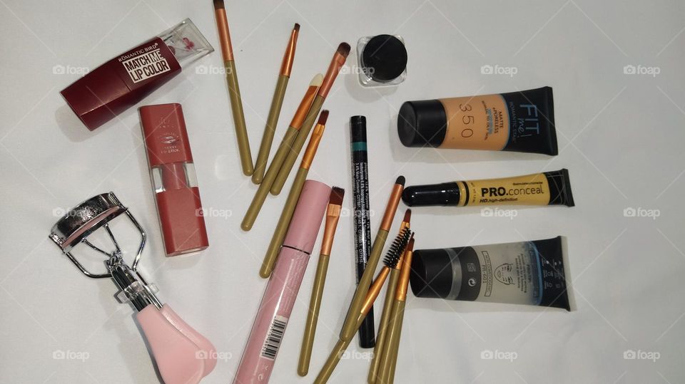 Different makeup products against a white background