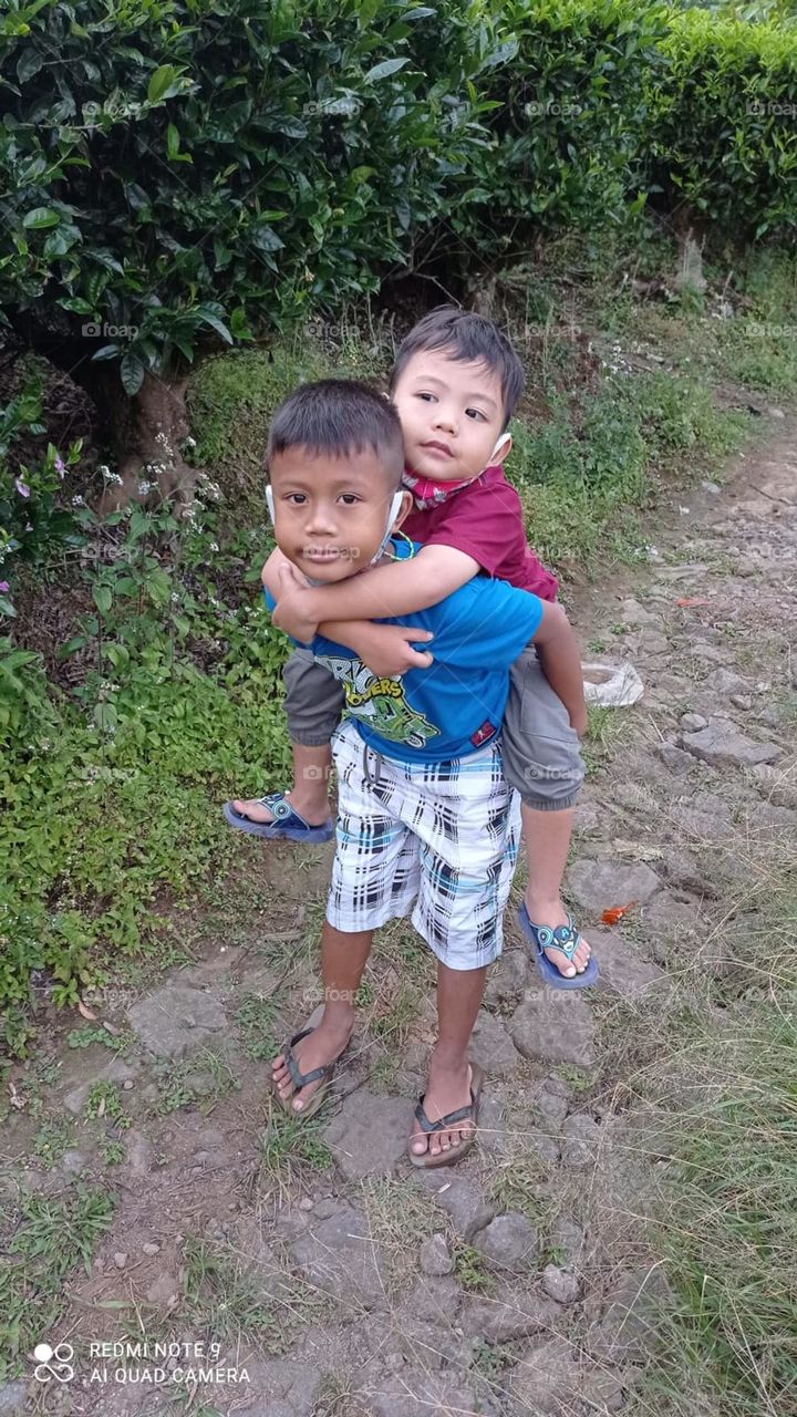 the two young boys looked so familiar while playing the familiarity was seen when they were playing on a path in a very peaceful village