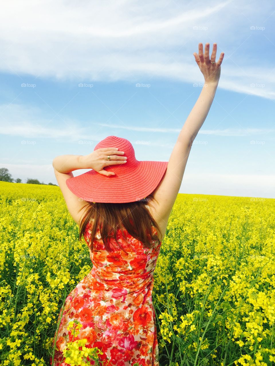 Rear view of girl standing in flower field