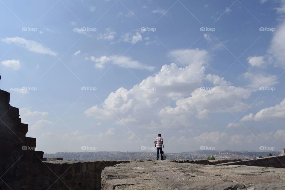 a young boy looks at Ankara city from the top of Ankara castle in Turkey