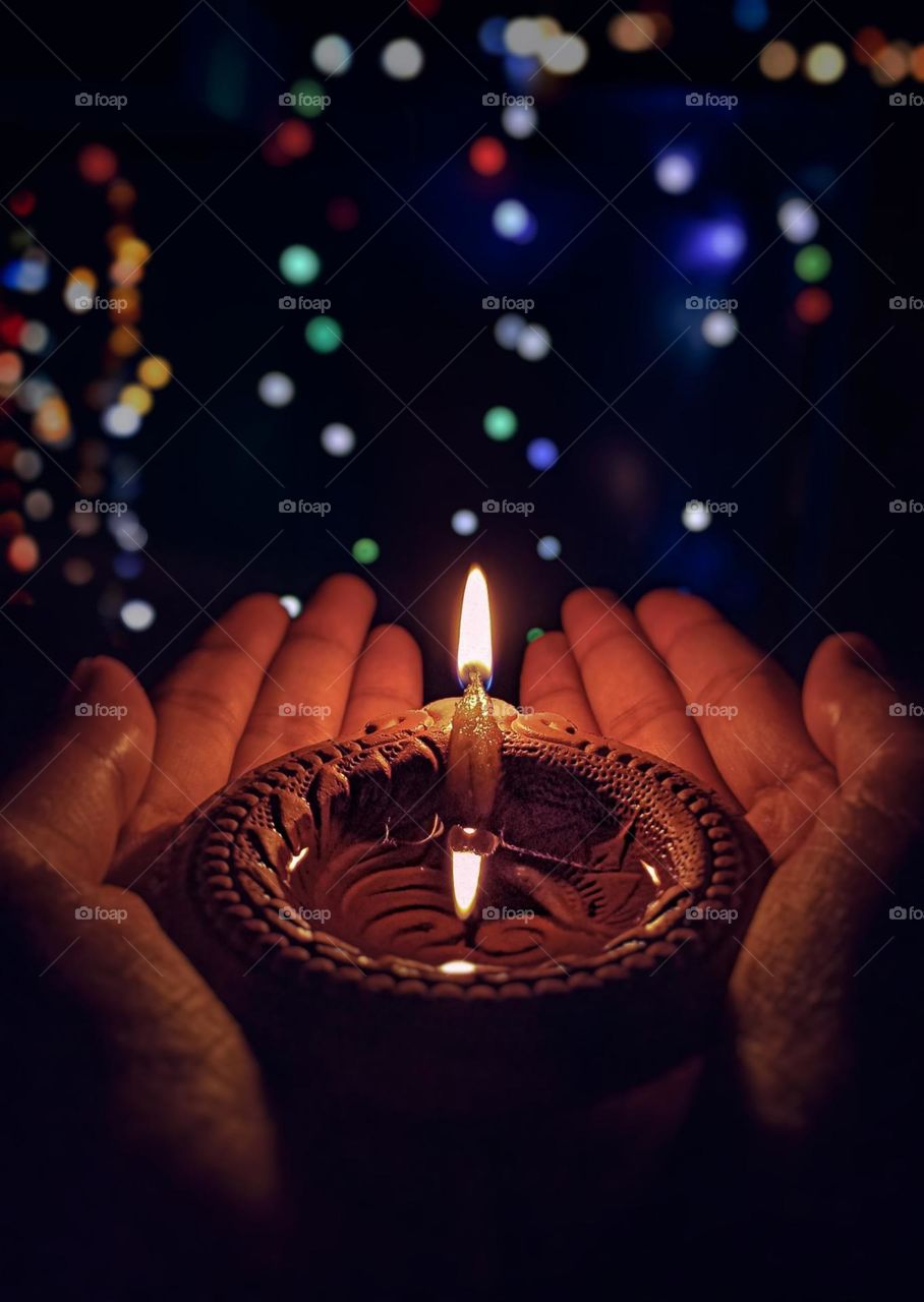 Brown Lighted diya on hand