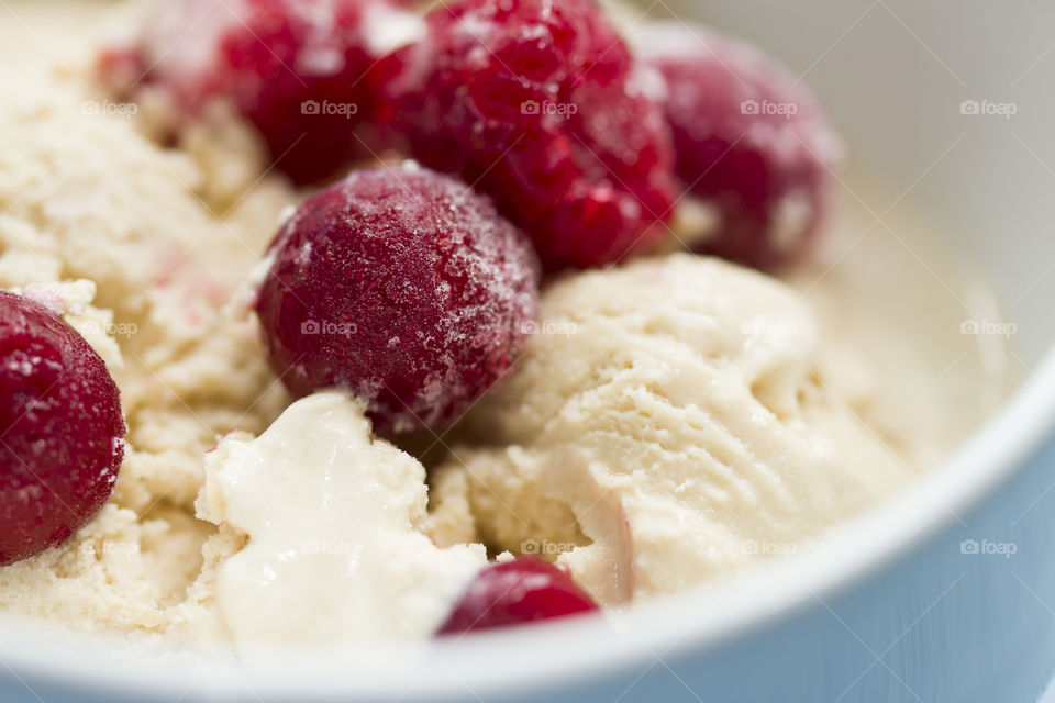 ice cream covered with fresh berries in white bowl