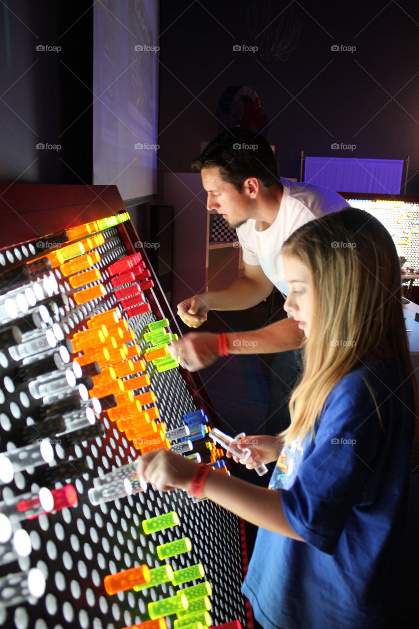 Come into the light. Dad and daughter playing with life size light brite