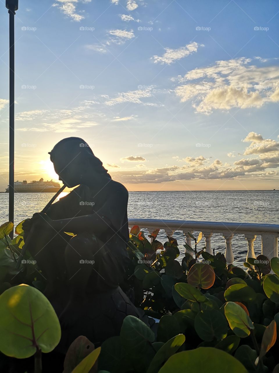 Beatiful and Amazing sunset in our paradise, cozumel Island, México. So lovely, with a pretty statue and a cruise ship on the ocean. The most Beatiful sunsets are in this big Island in the mexican caribbean.