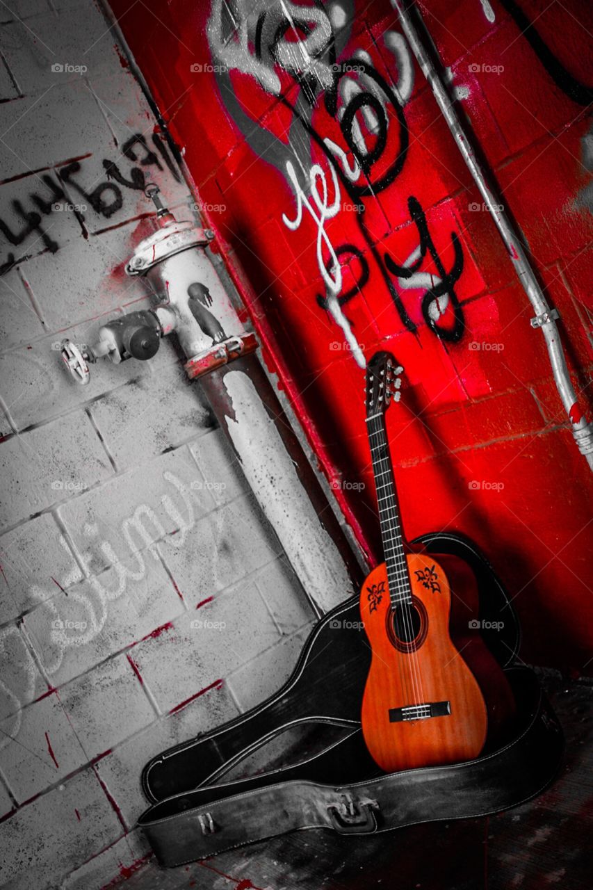Guitar on a graffiti wall.