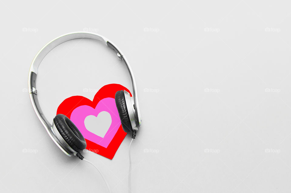 Valentine’s Day concept with headphones and heart on gray background with copy space 
