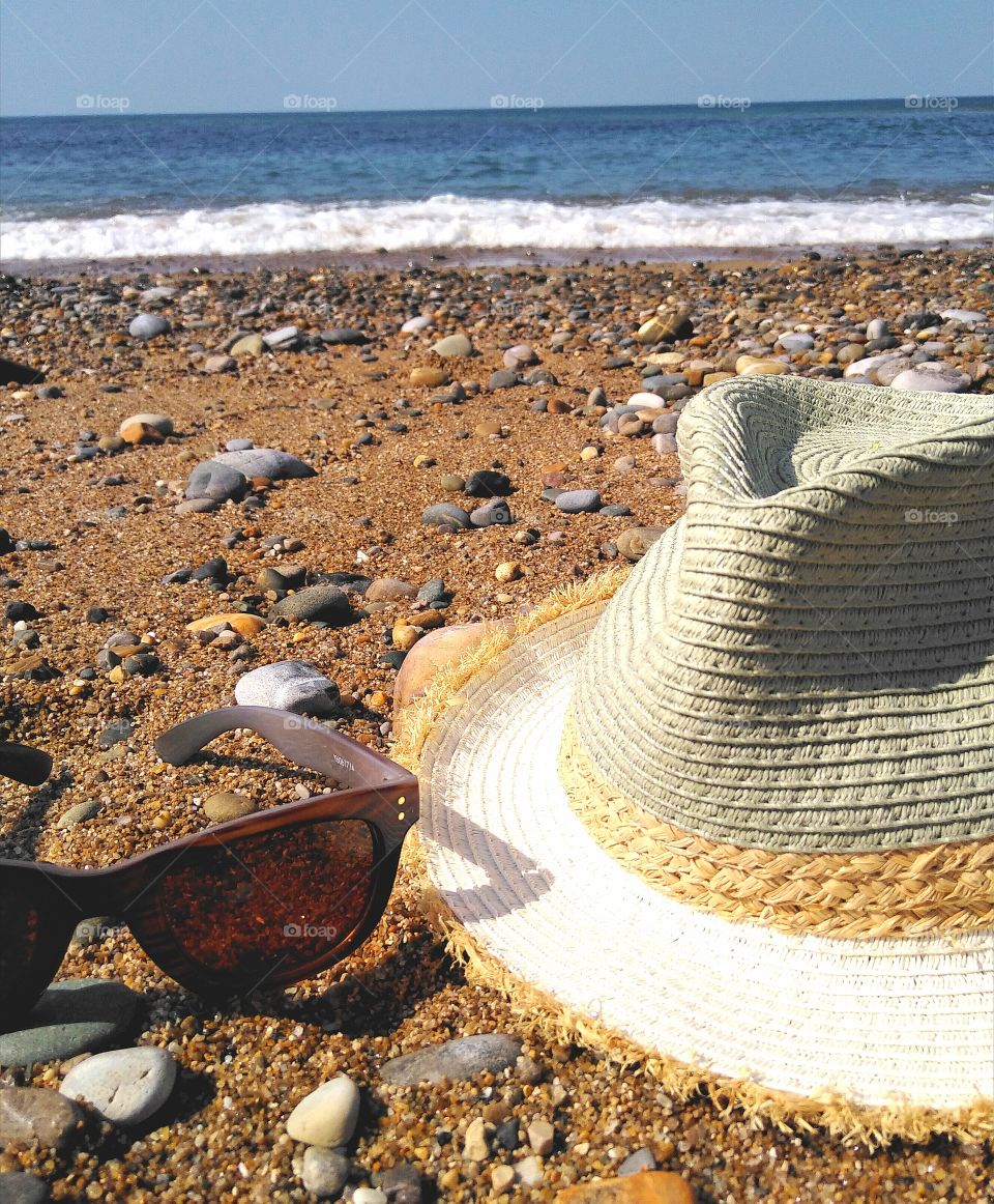 cap and sunglasses on the beach