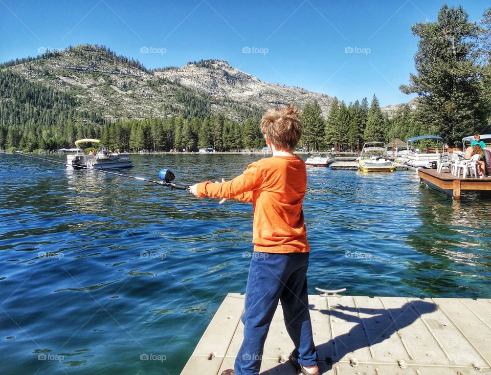 Little Boy Fishing In A Mountain Lake. Summertime Fishing
