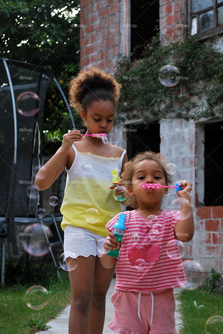 Two girls blowing bubbles