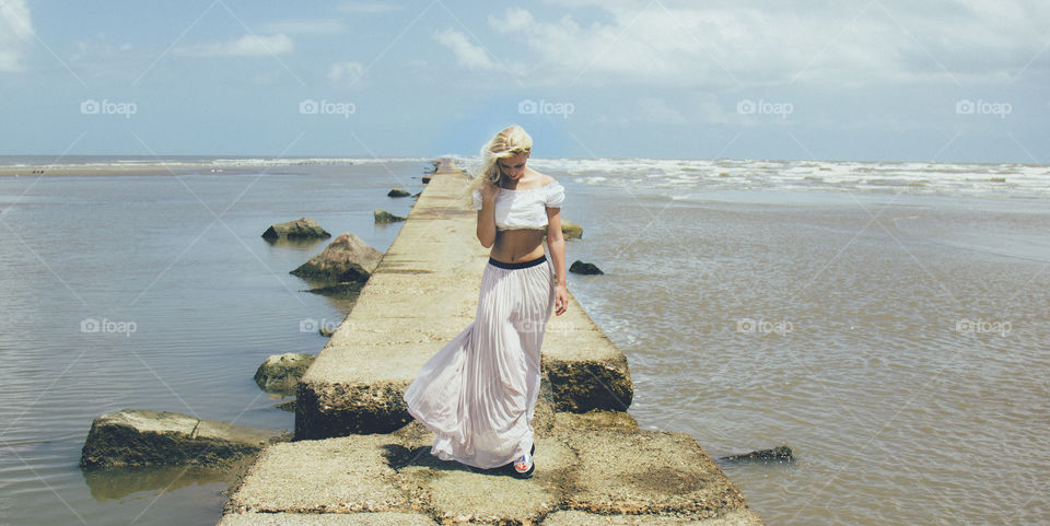 Woman walking on pier over the sea