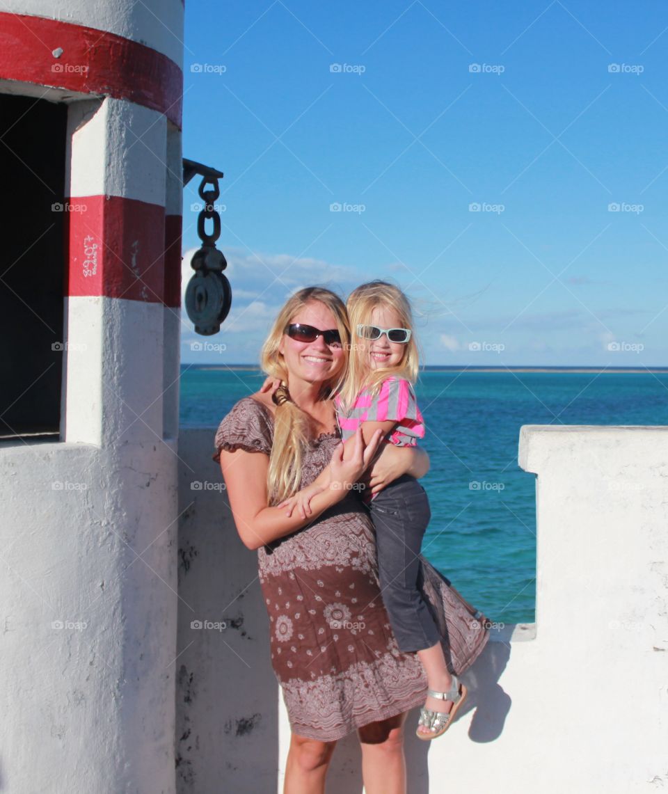 Mother and daughter at a lighthouse overlooking the ocean