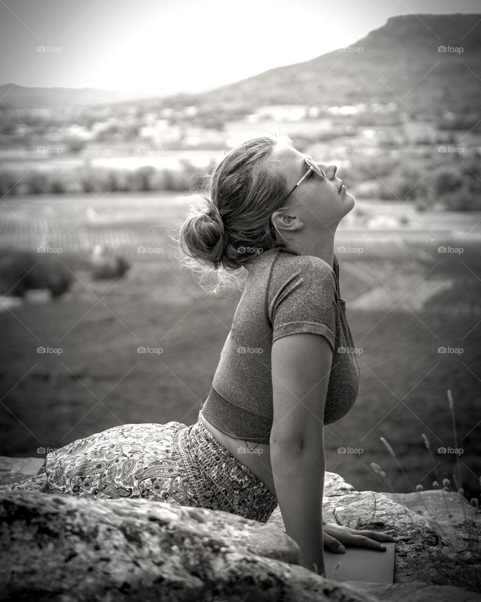 Young blonde woman practicing yoga on mountain top