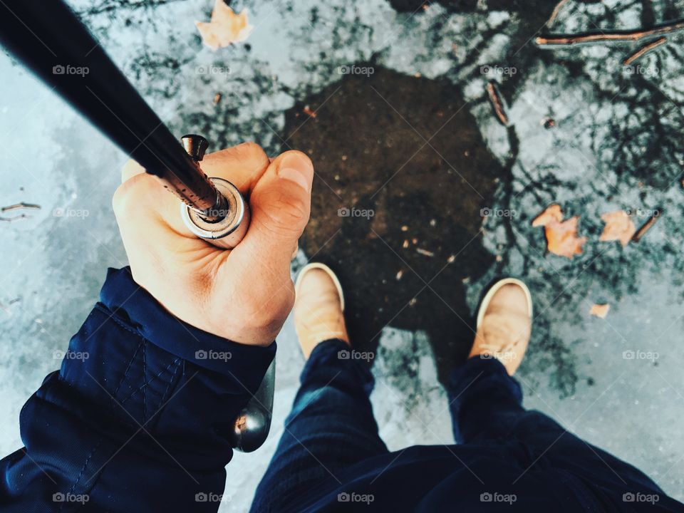 Elevated view of man holding umbrella in rain