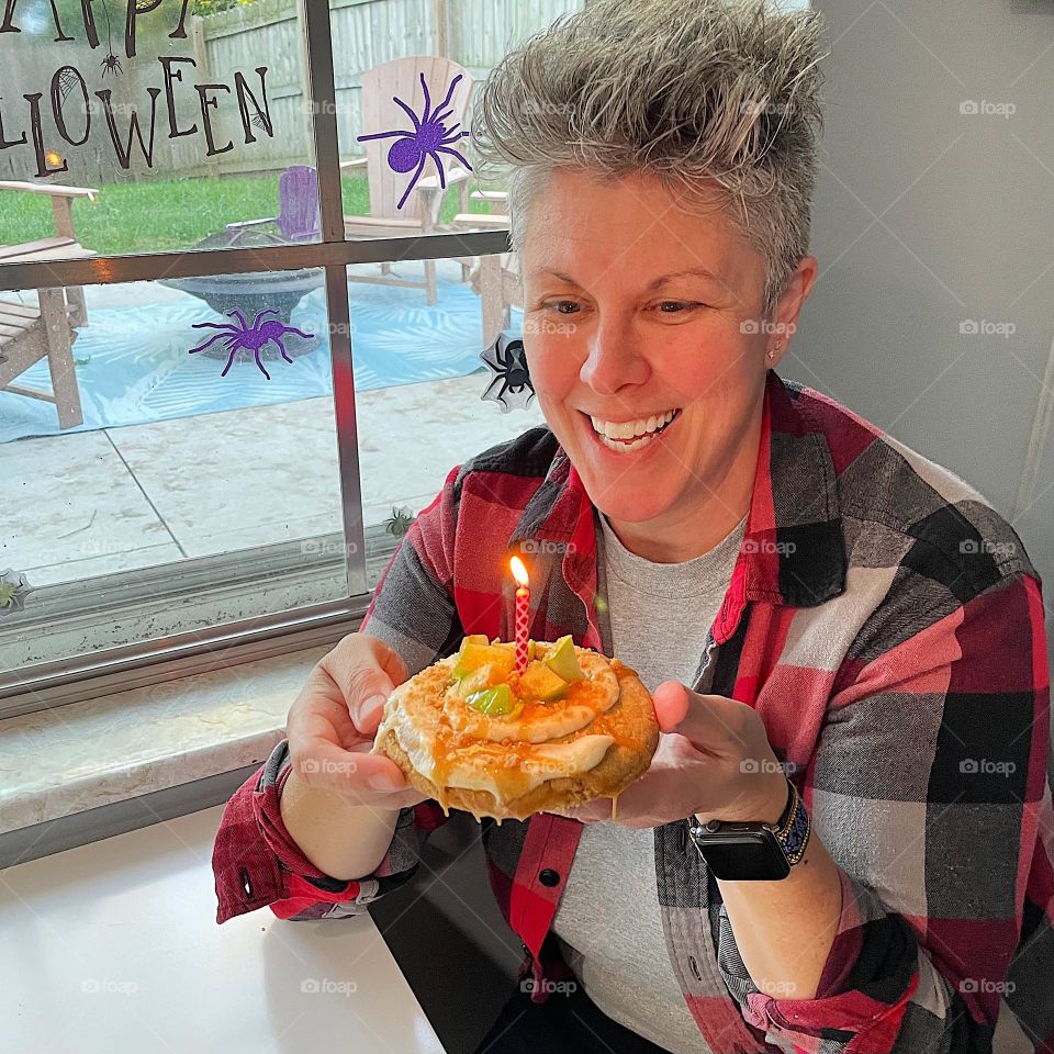 Woman blows out birthday candle, woman celebrates her birthday with Crumbl cookies, delicious Crumbl cookies 