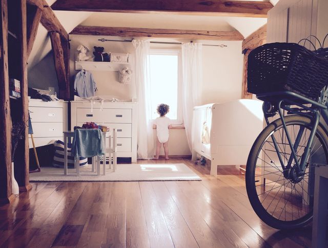 Lovely Boy looking though the window. Boy in the attic