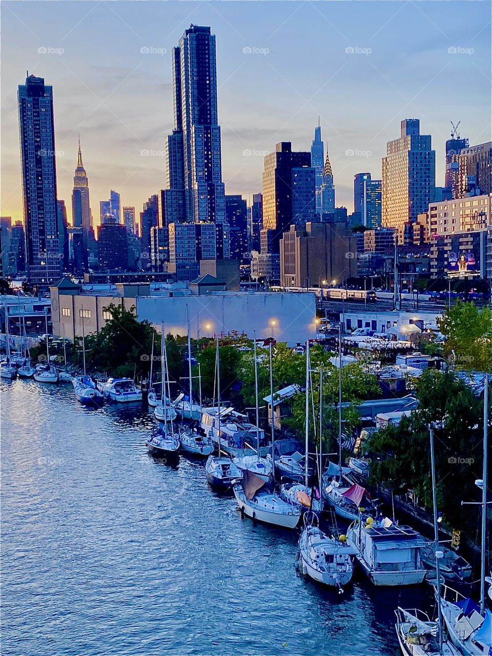 This is the view from the “Pulaski Bridge” at “Newtown Creek” in LIC, Queens on a gorgeous Indian summer evening in early October 2023. The boats in the creek and the combined skyline of LIC and of „Manhattan“ can be seen. Hypnotic Productions