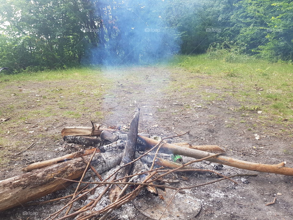 Been fire, burn with wood. Fire extinguished now. And passed into smoke. Outside in nature.