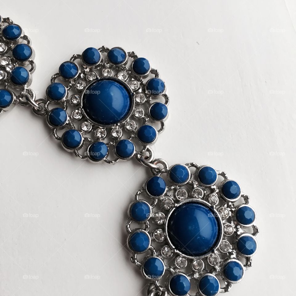 This piece of a blue necklace shows the contraste between blues , whites and greys . 