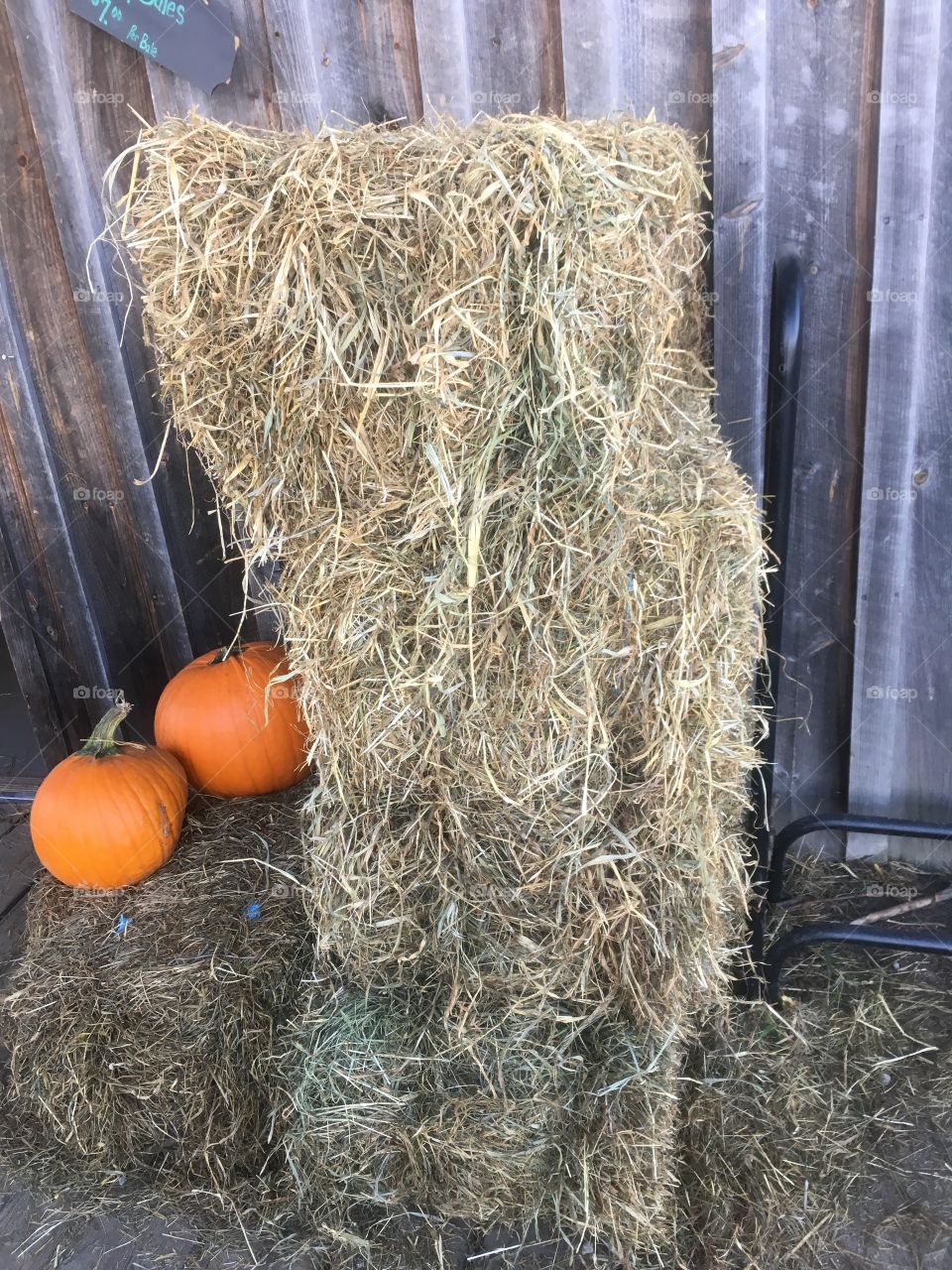 Pumpkins next to a hey bail at a local farm in northern Maine 