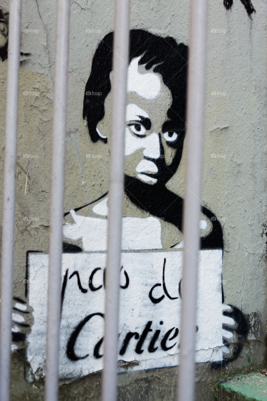 Pas de Cartier. Enfant dessiné sur un mur avec une pancarte "Pas de Cartier"