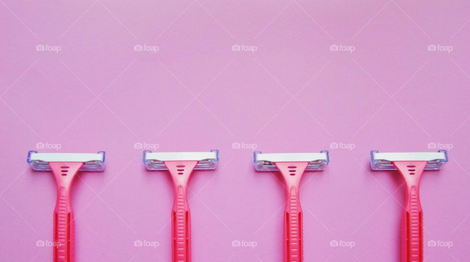 Photo of razors on pink background 