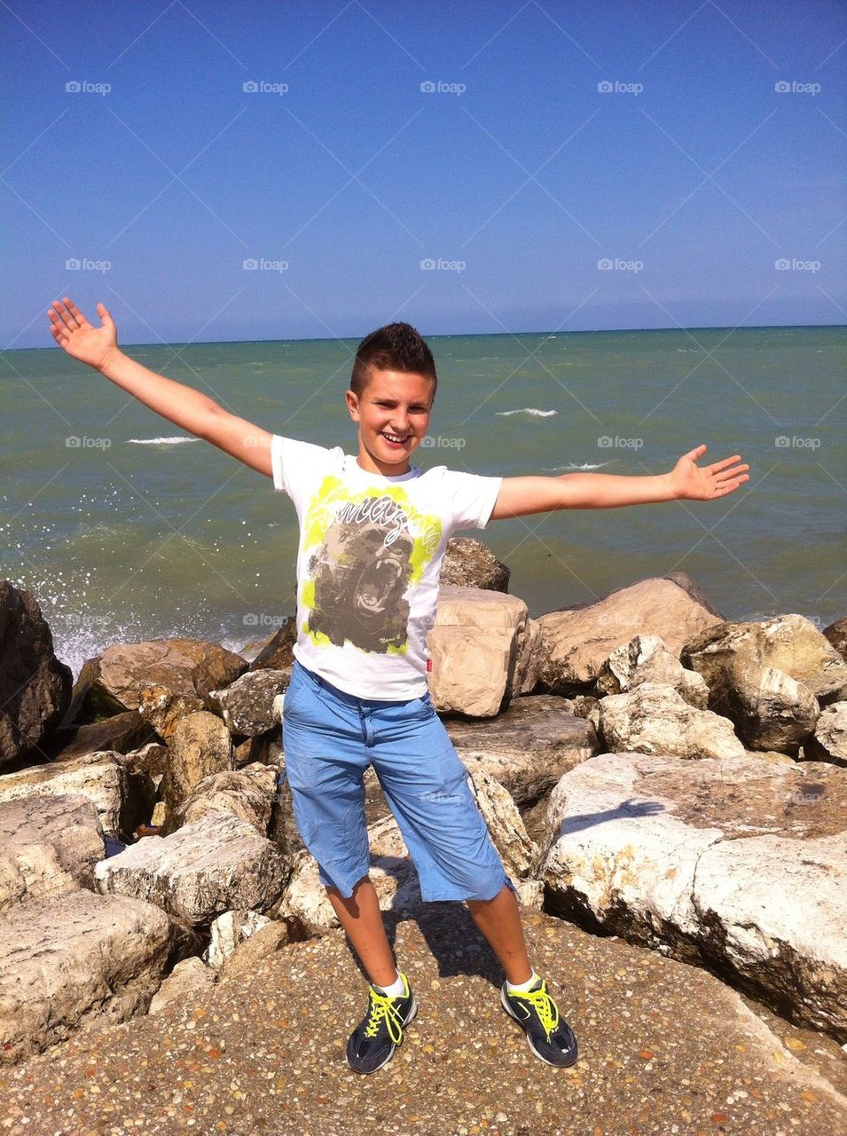 Happy young boy front of the sea during the summer season