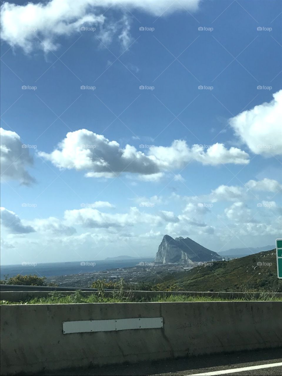 Rock of Gibraltar mountain with blue sky clouds and water 