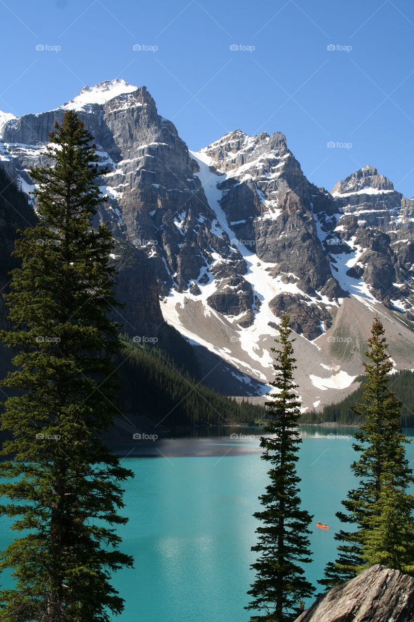  Majestic Canadian Rockies surround a glacier fed turquoise lake.