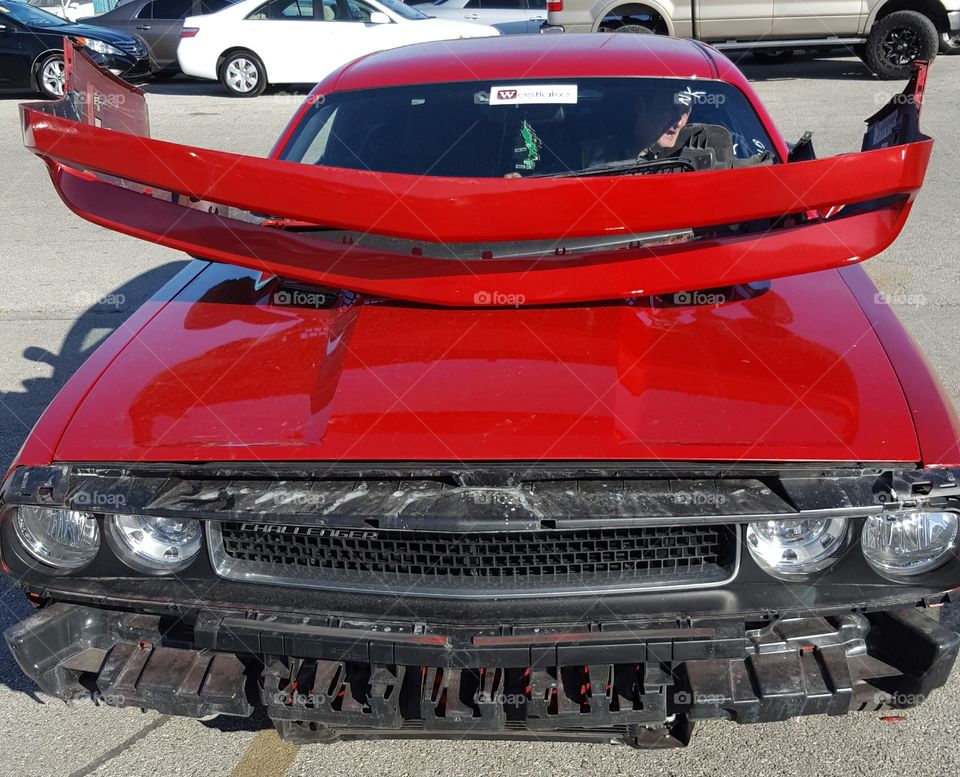 Red Dodge Challenger with the front bumper cover detatched.