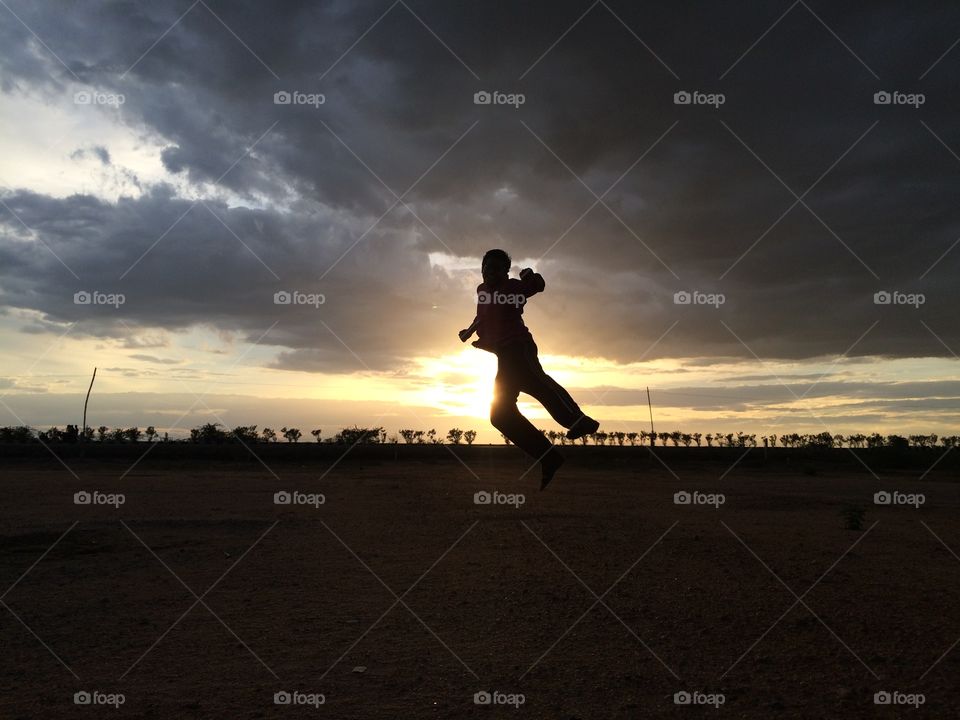 Silhouette of a man jumping during sunset