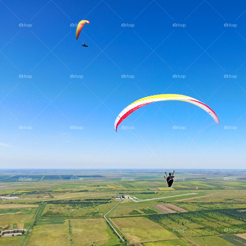 paragliders in the blue clear sky