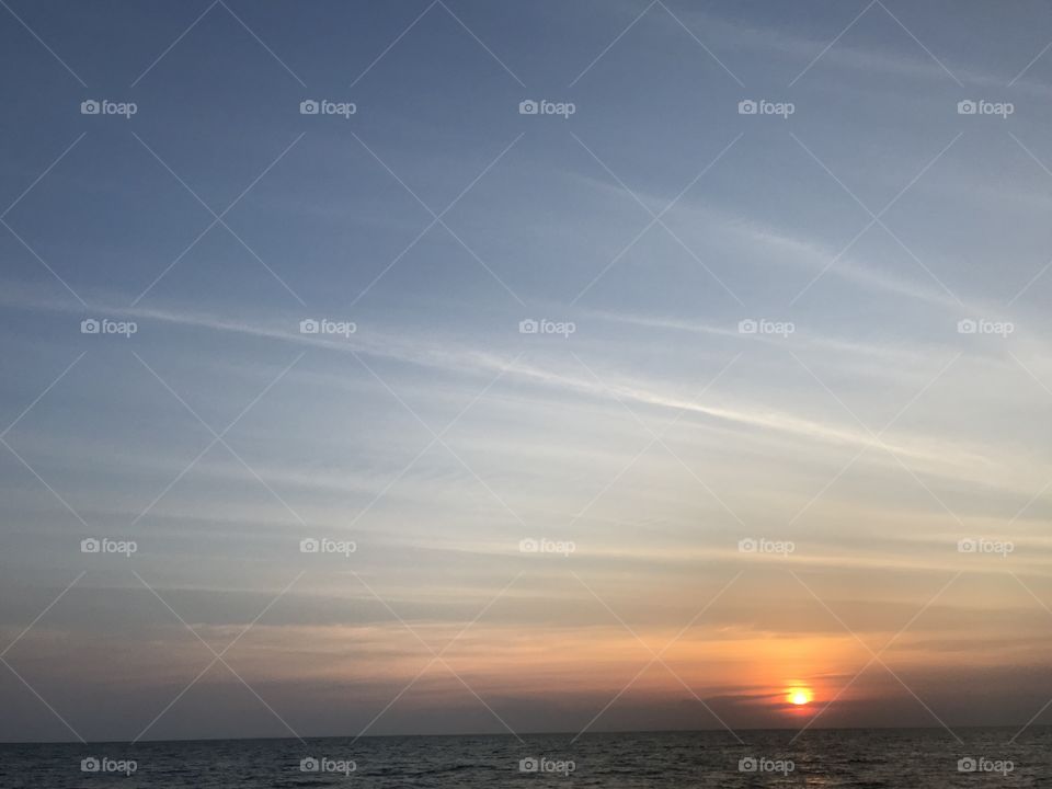 beautiful orange sunset light above the sea and blue sky and horizontal line