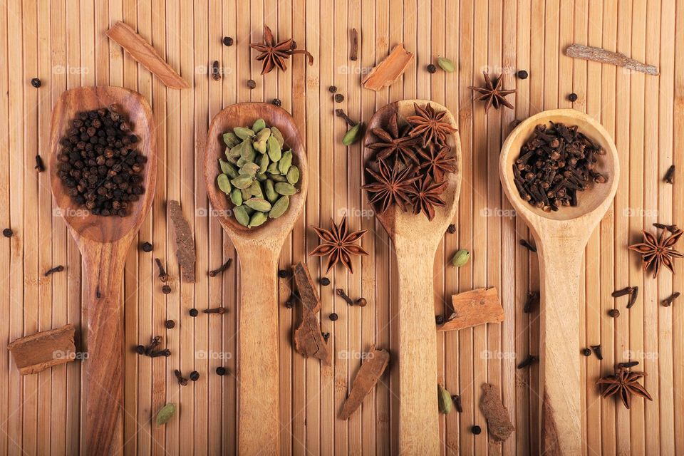 wooden spoons spatula on wooden background with fresh Indian spices