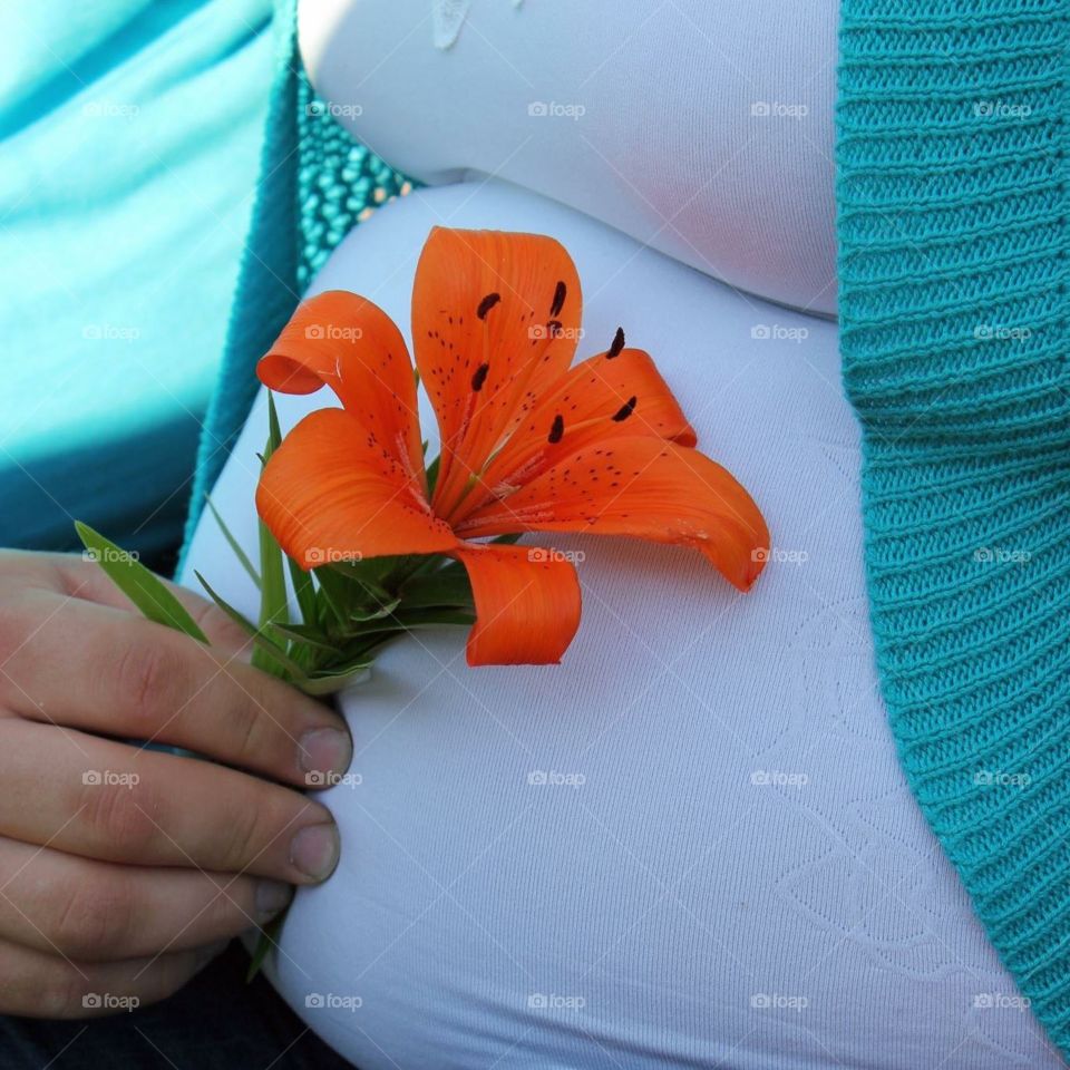 Maternity photo ...Dad gives baby first Tiger Lily