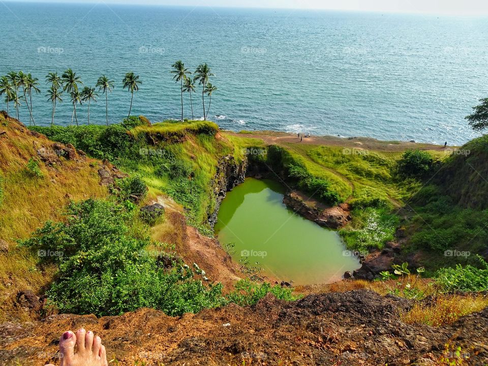 sitting on top and looking at the heart shaped lake by the sea in Goa, India