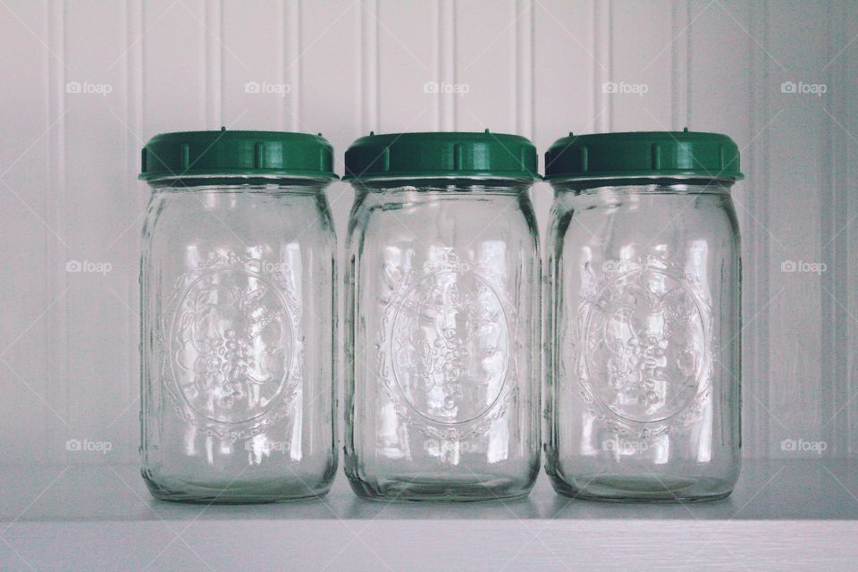 Green Color Story - mason jars with green lids on a white beadboard shelf