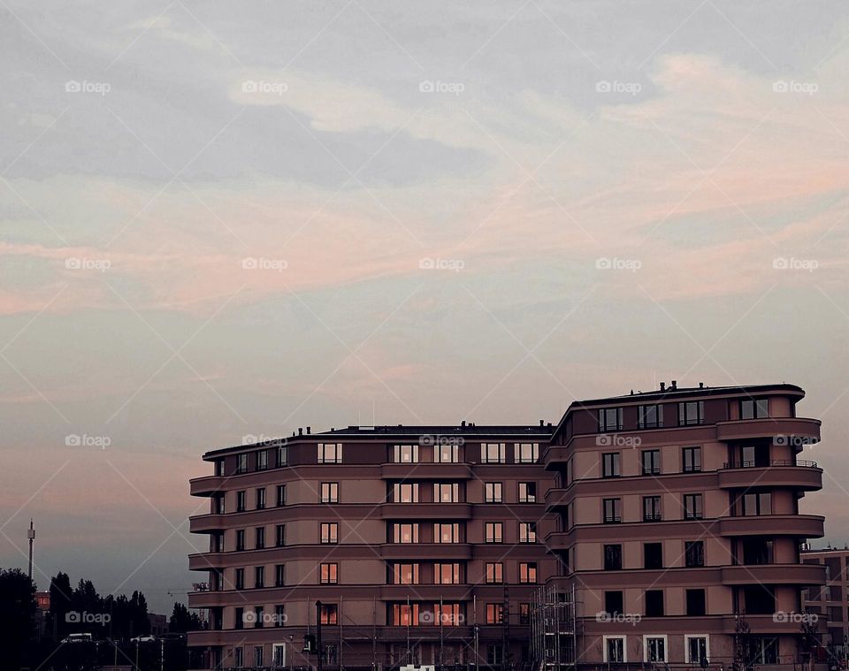 Isolated building is reflecting the sunset in the windows,every floor in an other colour of light