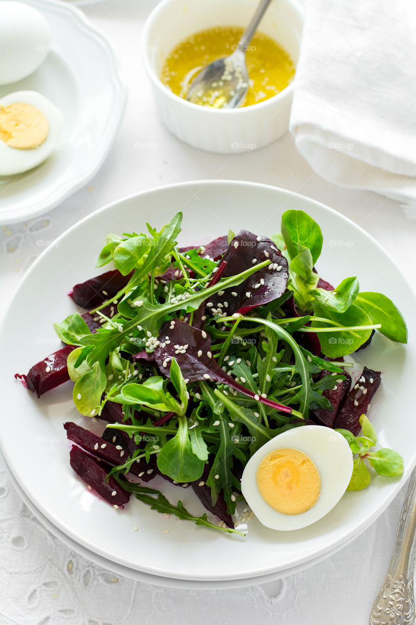Salad with beetroot, egg, sesame and lettuce mix