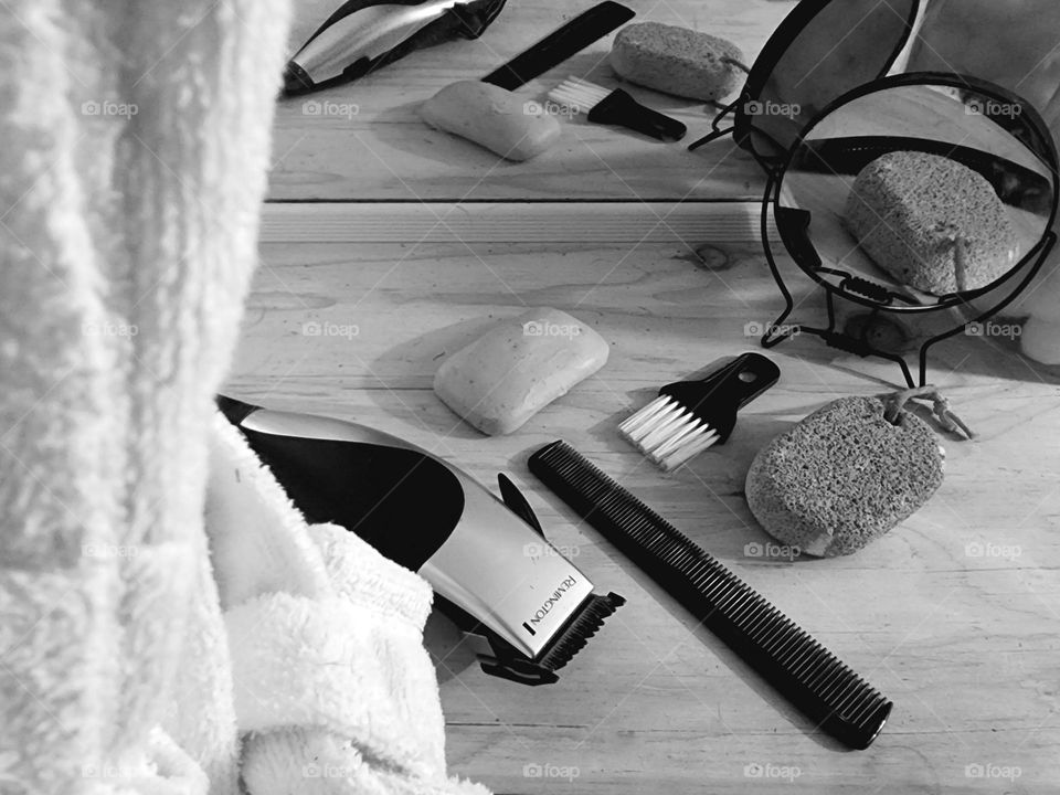 Men's shaving products laid out in front of the mirror with a bathrobe in the foreground.