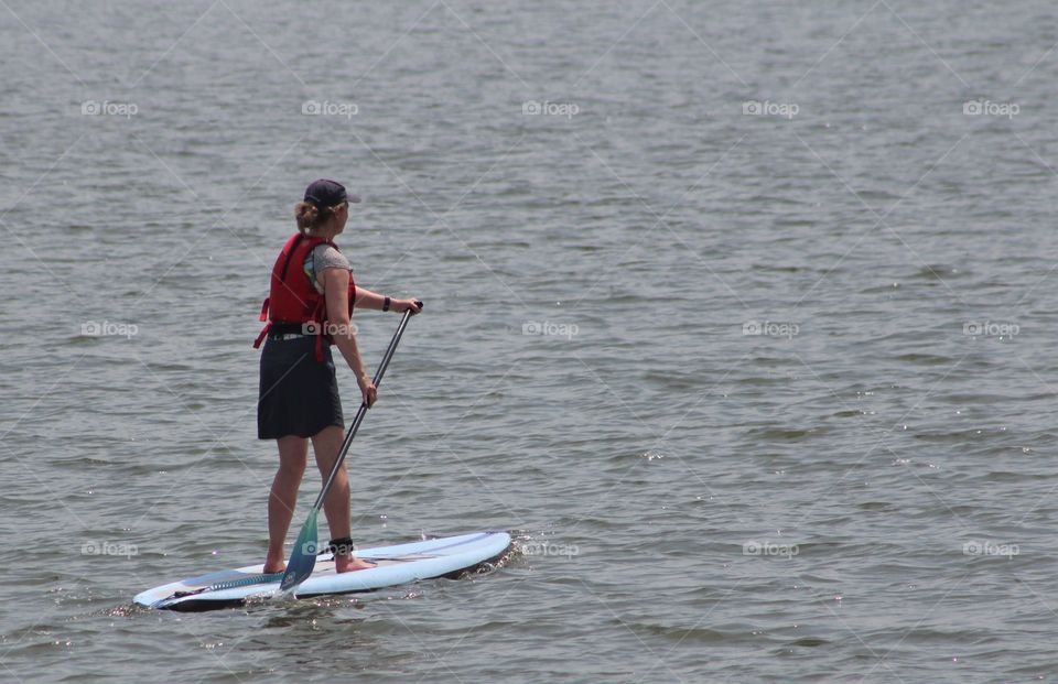 A female paddle boarder on Hudson River in June
