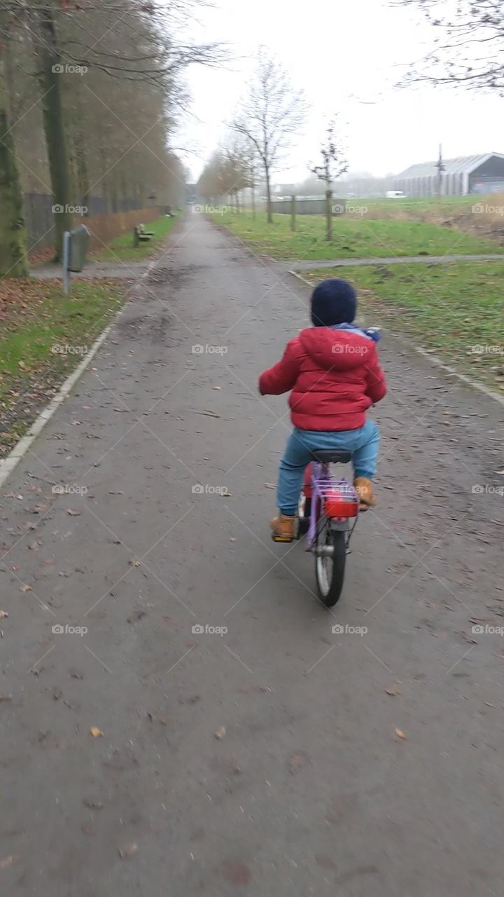 Little girl riding a bike in the park