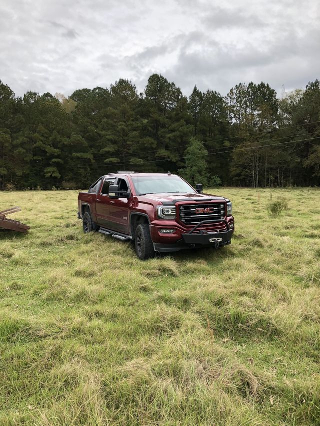 GMC Sierra 1500 pickup in a field.