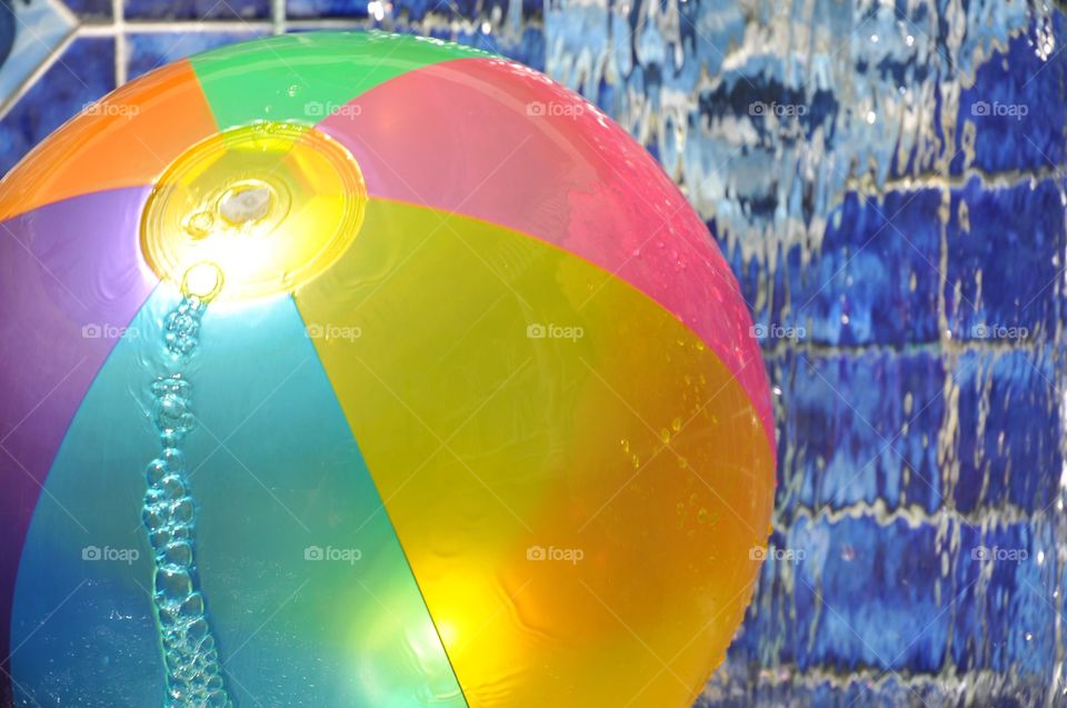 Colorful beach ball in a swimming pool. 