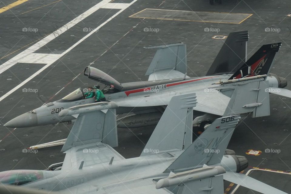 F-18 Super Hornets sit on deck waiting for the opportunity to fly